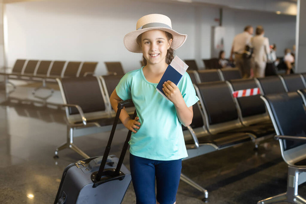 όμορφο κοριτσάκι με διαβατήριο και κάρτα επιβίβασης στο αεροδρόμιο - Φωτογραφία, εικόνα