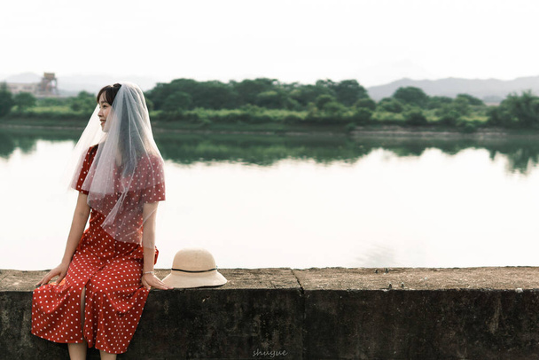 krásná mladá žena v bílých šatech a klobouk na pozadí řeky - Fotografie, Obrázek
