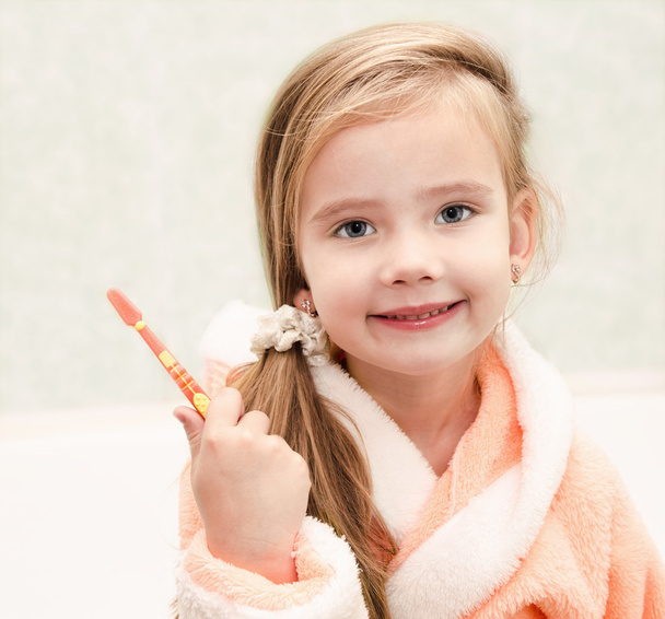 Smiling cute little girl brushing teeth  - Fotografie, Obrázek