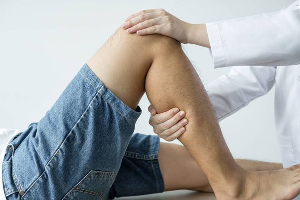 Пацієнти чоловічої статі консультувалися з фізіотерапевтами з проблемами болю в коліні для огляду та лікування. Реабілітаційна фізіотерапія концепція
. - Фото, зображення