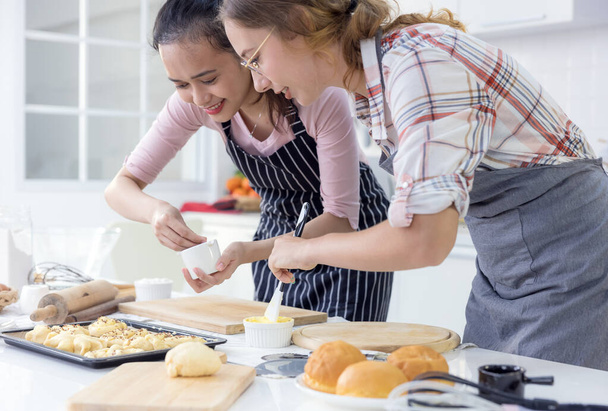 Dívka peče sušenky, Rodina Teenage ženy dvě multietnické jsou vaření chleba. Pekárna doma v kuchyni. Víkendové vaření pro mladé lidi. koncepce životního stylu. Online kurzy vaření, které zůstávají doma. - Fotografie, Obrázek