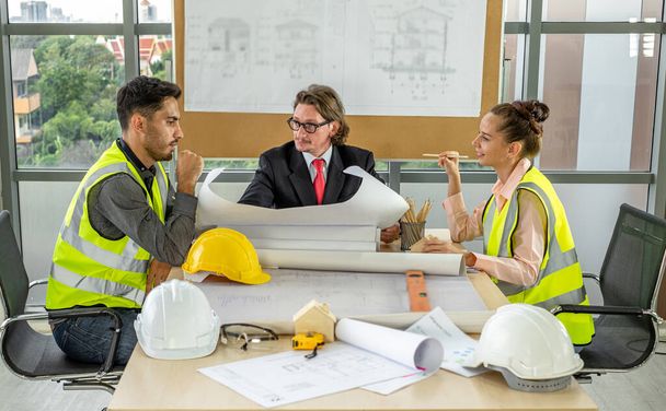 Team of male and female engineers and architects, working team, meeting, discussing construction and drawing construction plans, printing, writing on-site construction sites. - Photo, Image