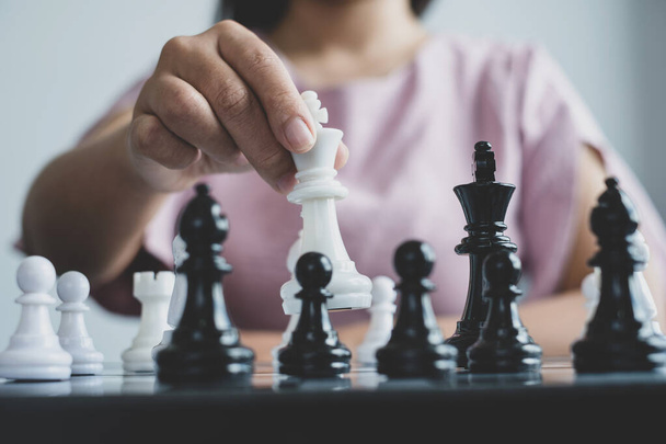 Hand of businesswoman moving, chess in competition shows leadership, followers, and business success strategies. - Foto, Imagen