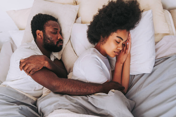 Afro american couple in bed - Real beautiful and cheerful pair of lovers at home - Foto, Bild