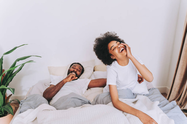 Afro american couple in bed - Real beautiful and cheerful pair of lovers at home - Φωτογραφία, εικόνα