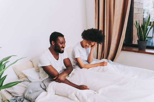 Afro american couple in bed - Real beautiful and cheerful pair of lovers at home - Zdjęcie, obraz