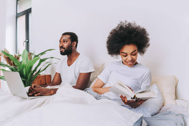 Afro american couple in bed - Real beautiful and cheerful pair of lovers at home - Foto, Imagen