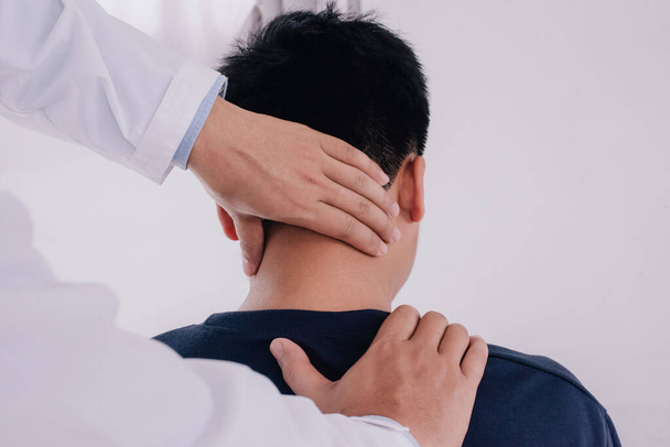 Doctor doing neck adjustment in medical office. Physical rehabilitation therapies and treatment of physiological disorders by physiotherapists concept - Photo, image