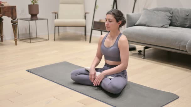 Mujer india pacífica meditando en la esterilla de yoga en casa - Imágenes, Vídeo