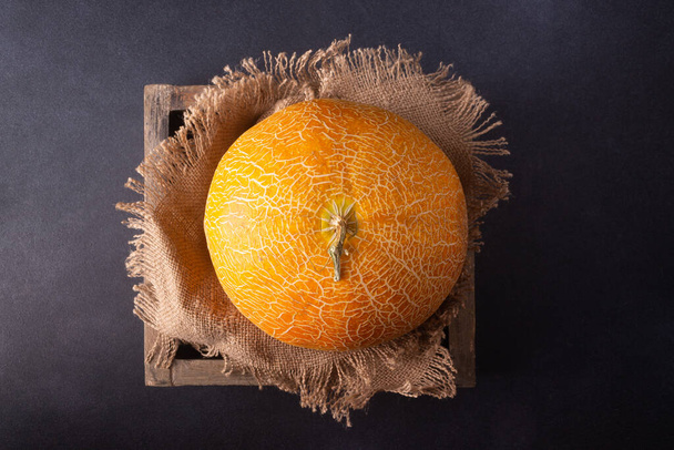 Melon in a wooden box with a canvas cloth. - Фото, изображение