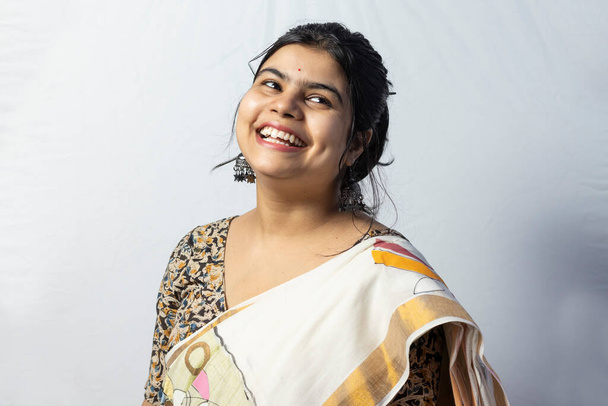 Vereinzelt auf weißem Hintergrund eine indische Frau im Sarg mit breitem Lächeln, die zur Seite schaut - Foto, Bild