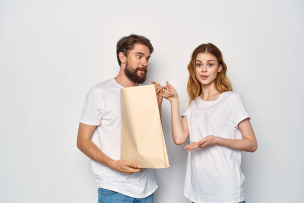 mężczyzna z papierową torbą obok kobieta zakupy rodzinne emocje - Zdjęcie, obraz