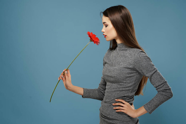 brunetta con fiore rosso trucco luminoso glamour romanticismo primo piano - Foto, immagini