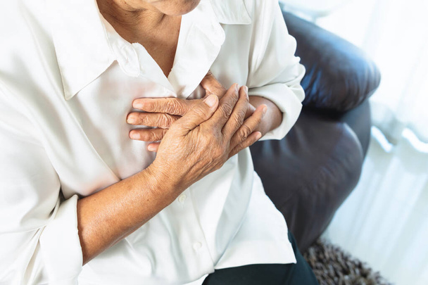 alte Frau erleidet Herzinfarkt und fasst sich an die Brust - Foto, Bild