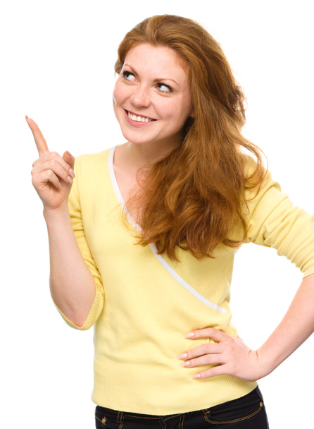 Portrait of a young woman pointing to the left - Foto, Bild