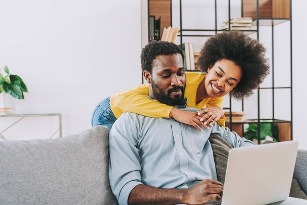 Beautiful afro-american couple working on computer laptop device - Modern couple shopping online - 写真・画像