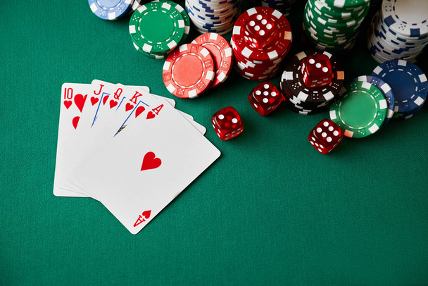 Casino chips, playing cards and dices on green fabric table - Фото, зображення