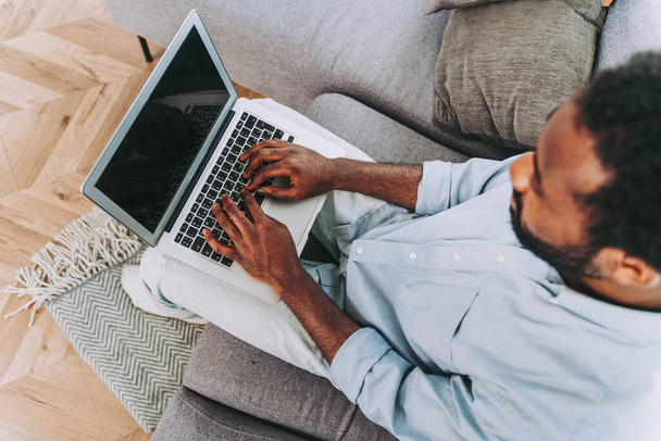Guapo negro adulto hombre trabajando con ordenador portátil en casa - Foto, imagen