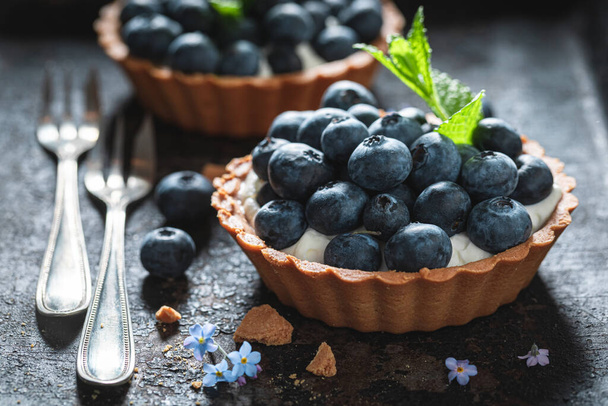 Delicious mini tart with blueberries. Sweet summer dessert. Tart with cream and berries. - Foto, afbeelding