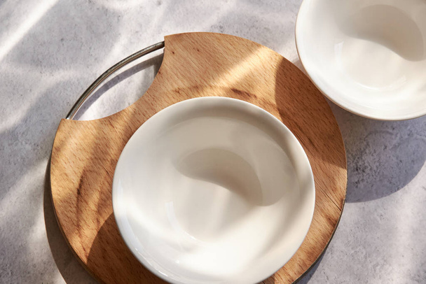 Empty white bowls on concrete, on a sunny table - Zdjęcie, obraz