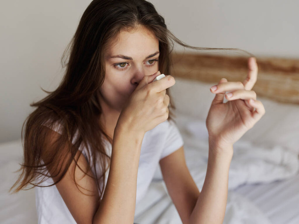 woman checks the temperature with a thermometer in her mouth - Photo, Image
