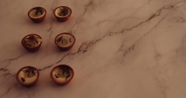 A closeup shot of burnt out Diwali candles on a marble surface - Photo, Image