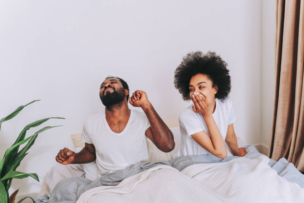 Afro american couple in bed - Real beautiful and cheerful pair of lovers at home - Foto, Bild