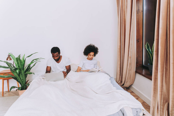 Afro american couple in bed - Real beautiful and cheerful pair of lovers at home - Zdjęcie, obraz