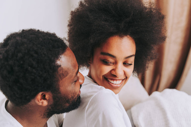 Afro american couple in bed - Real beautiful and cheerful pair of lovers at home - Fotografie, Obrázek
