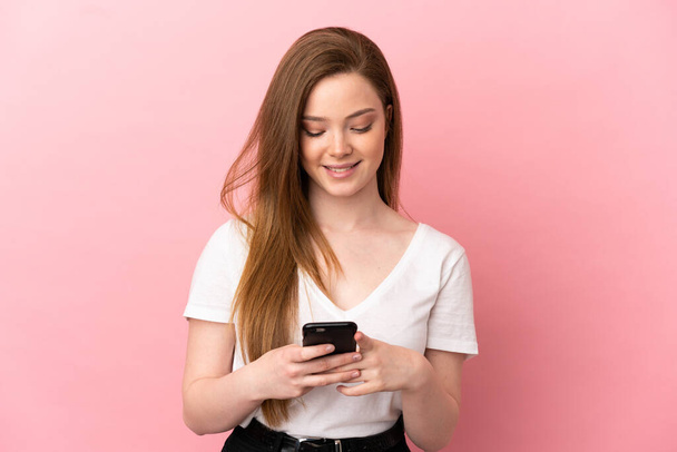 Teenager girl over isolated pink background sending a message or email with the mobile - Foto, immagini