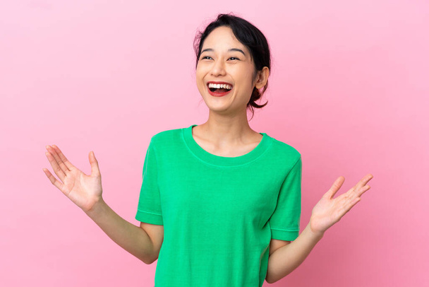 Joven vietnamita aislada sobre fondo rosa sonriendo mucho - Foto, imagen