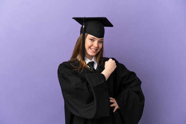 Graduação universitária jovem sobre fundo roxo isolado celebrando uma vitória - Foto, Imagem