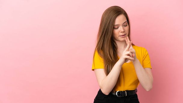 Teenager girl over isolated pink background showing victory sign with both hands - 写真・画像