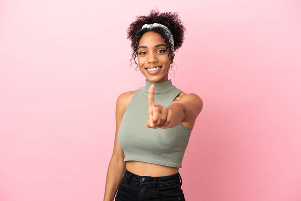 Young latin woman isolated on pink background showing and lifting a finger - Фото, изображение