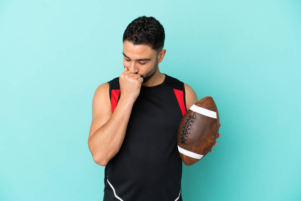 Young arab man playing rugby isolated on blue background having doubts - Photo, Image