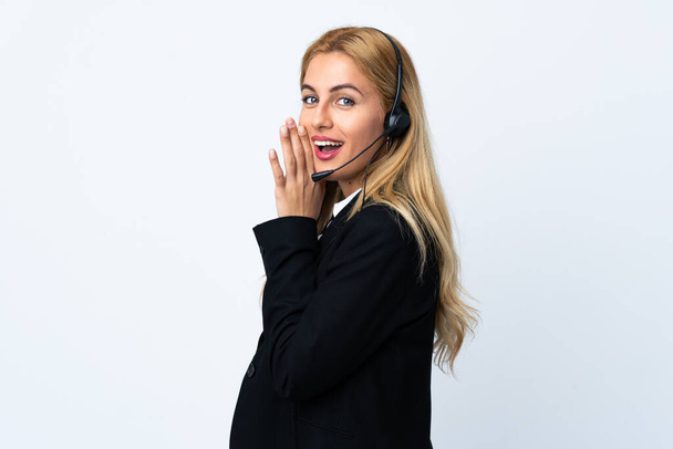 Young telemarketer woman over isolated white background whispering something - Photo, Image
