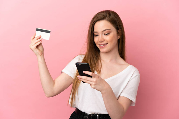 ティーン少女以上隔離されたピンクの背景購入とともにザモバイルとともにクレジットカード - 写真・画像
