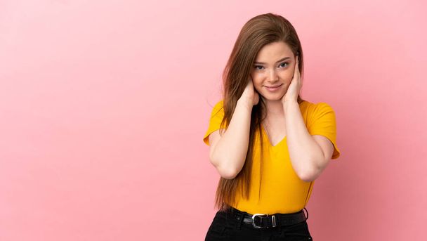 Teenager girl over isolated pink background frustrated and covering ears - Photo, Image