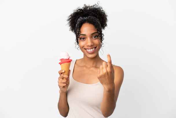 Young african american woman with a cornet ice cream isolated on white background doing coming gesture - Фото, изображение