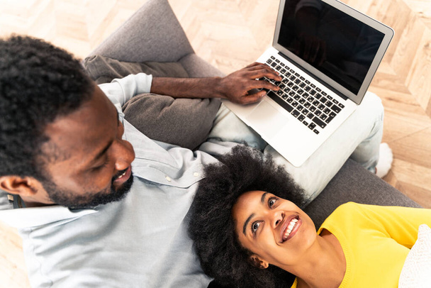 Beautiful afro-american couple working on computer laptop device - Modern couple shopping online - Foto, Imagem