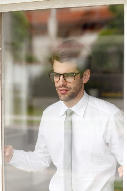 Businessman standing behind window - Фото, зображення