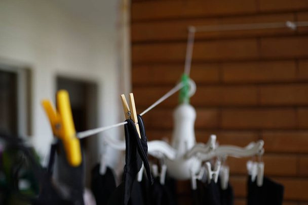 A closeup shot of clothes hanging up for drying on a clothesline - Photo, Image