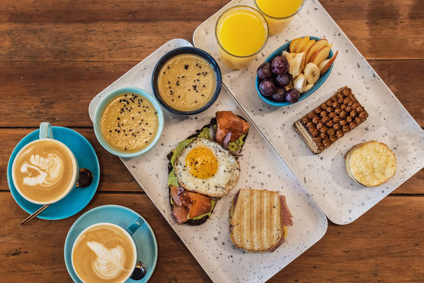 A high angle shot of a breakfast table with coffee, egg toast and fruits - Zdjęcie, obraz