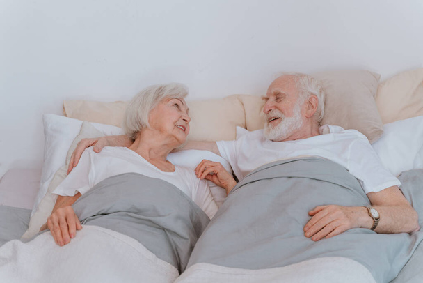 Beautiful senior couple enjoying time together at home - Romantic moments at home, elderly couple in bed at home - Fotoğraf, Görsel