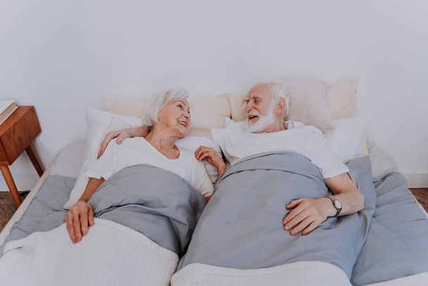 Beautiful senior couple enjoying time together at home - Romantic moments at home, elderly couple in bed at home - Fotografie, Obrázek