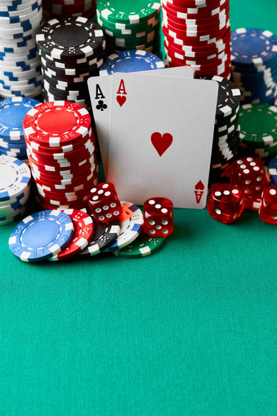 Casino chips, playing cards and dices on green fabric table - Photo, image