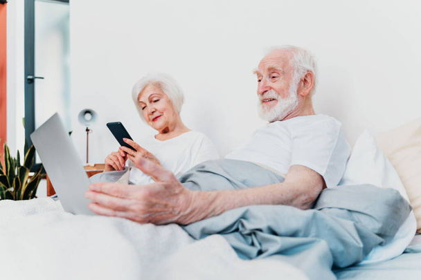 Beautiful senior couple enjoying time together at home - Moder elderly couple surfing the internet on laptop computer - Φωτογραφία, εικόνα