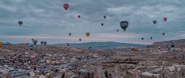 Goreme, Turkey - March 20, 2020 - tourist hot air balloons flying over the town of Goreme in Cappadocia, Turkey at sunrise - Foto, immagini