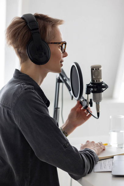 Young and confident European woman recording a podcast in a recording studio - Fotoğraf, Görsel