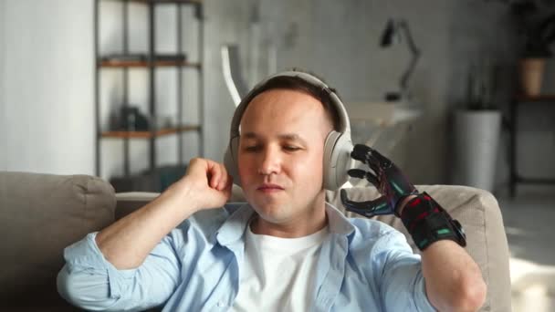 Gehandicapte man met handprothese luistert naar favoriete track - Video
